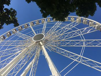 Low angle view of ferris wheel against clear blue sky