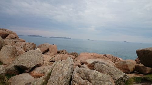 Rocks on sea shore against sky