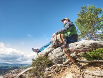 Man traveler sitting on rocky bench enjoying beautiful mountain view. travel. hiking in mountain.