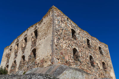 Low angle view of old building against blue sky