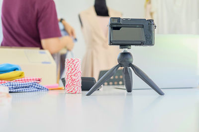 Close-up of camera on tripod at table