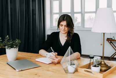 Business girl freelancer in casual clothes works using wireless technology in the home office