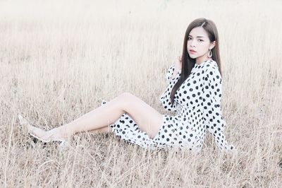 Portrait of a young woman sitting on land