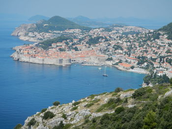 High angle view of townscape by sea against sky
