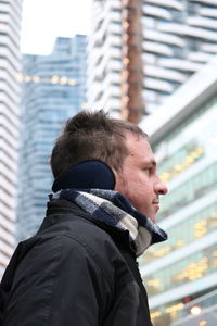 Low angle view of man standing against buildings in city
