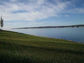 Scenic view of grassy field against cloudy sky