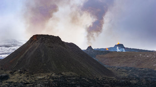 Smoke emitting from volcanic mountain against sky