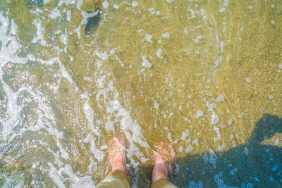 Low section of man swimming in sea