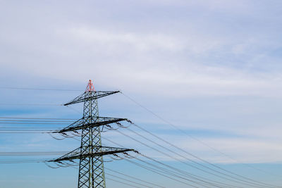 Low angle view of electricity pylon against sky