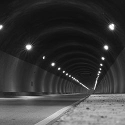 Empty road in illuminated tunnel