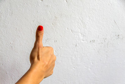 Close-up of human hand on white wall