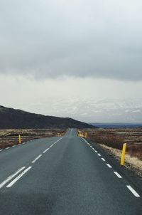 Empty road against cloudy sky