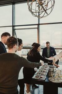 Male and female colleagues having food during company party