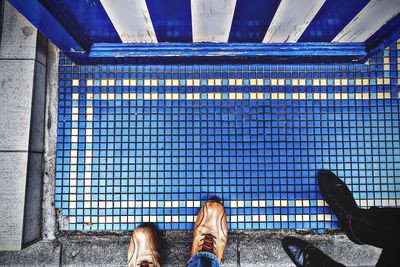 Low section of people standing by tiled floor