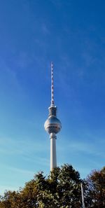 Low angle view of communications tower against blue sky