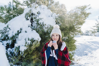 Woman holding coffee cup in snow