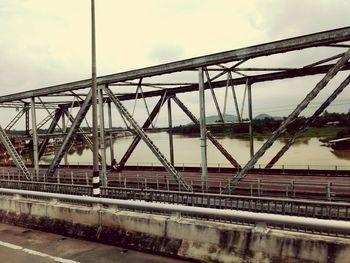 Bridge over river against sky in city