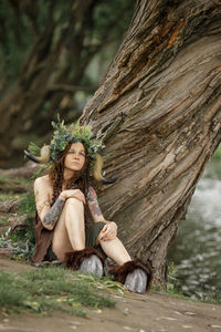 Portrait of young woman sitting in forest