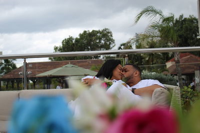 Couple kissing against sky