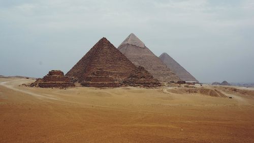 Pyramids in desert against sky