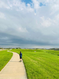 Rear view of man on field against sky
