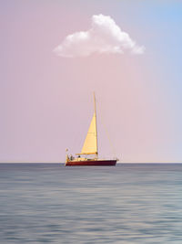 Sailboat sailing on sea against sky during sunset