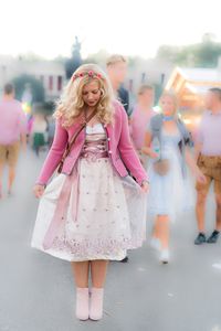 Happy woman with arms raised in city