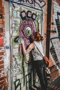 Full length of woman standing on graffiti