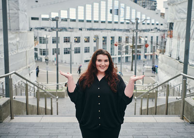 Portrait of smiling young woman standing in city