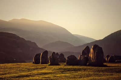 Scenic view of agricultural field against mountains at sunset