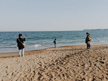 People on beach against sky