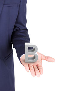 Midsection of man holding mobile phone against white background