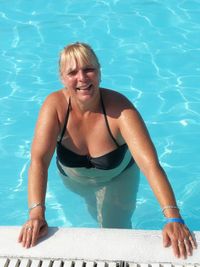 Portrait of a smiling young woman swimming in pool