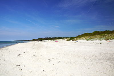 Scenic view of beach against blue sky