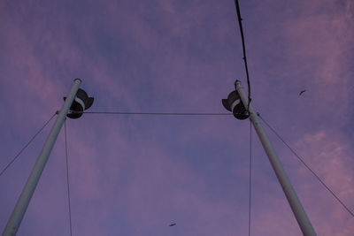 Low angle view of birds on cable against sky