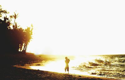 Silhouette of woman on beach during sunset