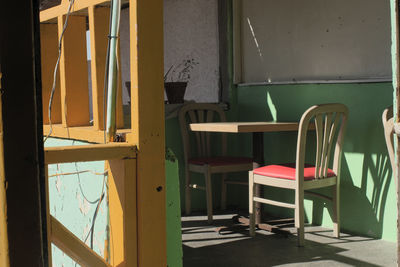 Empty chairs and table in abandoned building