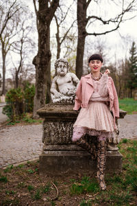 Portrait of a smiling woman standing against trees