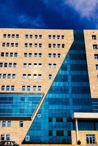 Low angle view of office building against blue sky