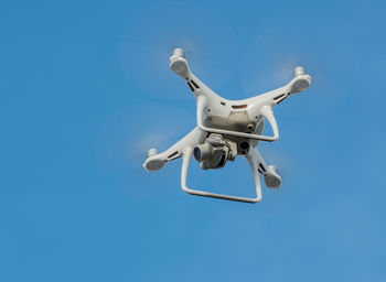 Low angle view of drone flying against sky