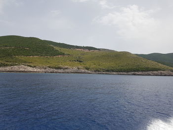 Scenic view of sea and mountains against sky