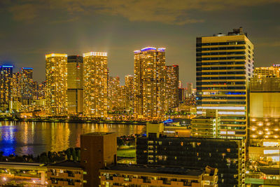 Illuminated buildings in city against sky at night