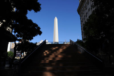 Low angle view of steps amidst buildings against sky