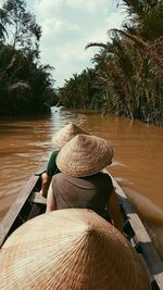 Rear view of people sailing in river