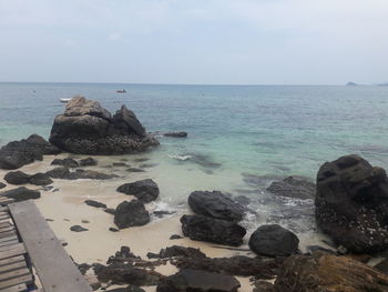 Rocks on sea shore against sky