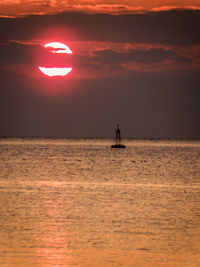 Silhouette boat sailing in sea against sky during sunset