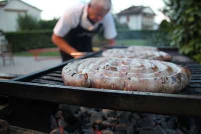 Close-up of man preparing food on barbecue grill