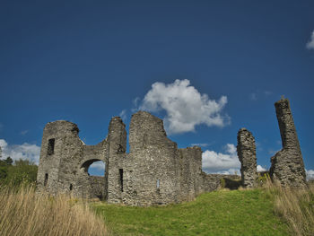 Old ruins on field against sky