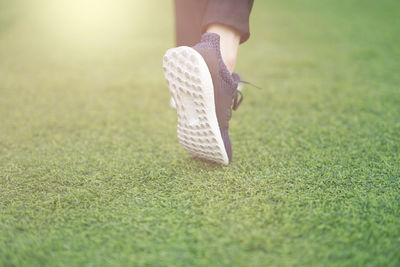 Low section of woman standing on field