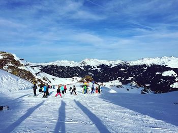 People enjoying at ski resort against sky